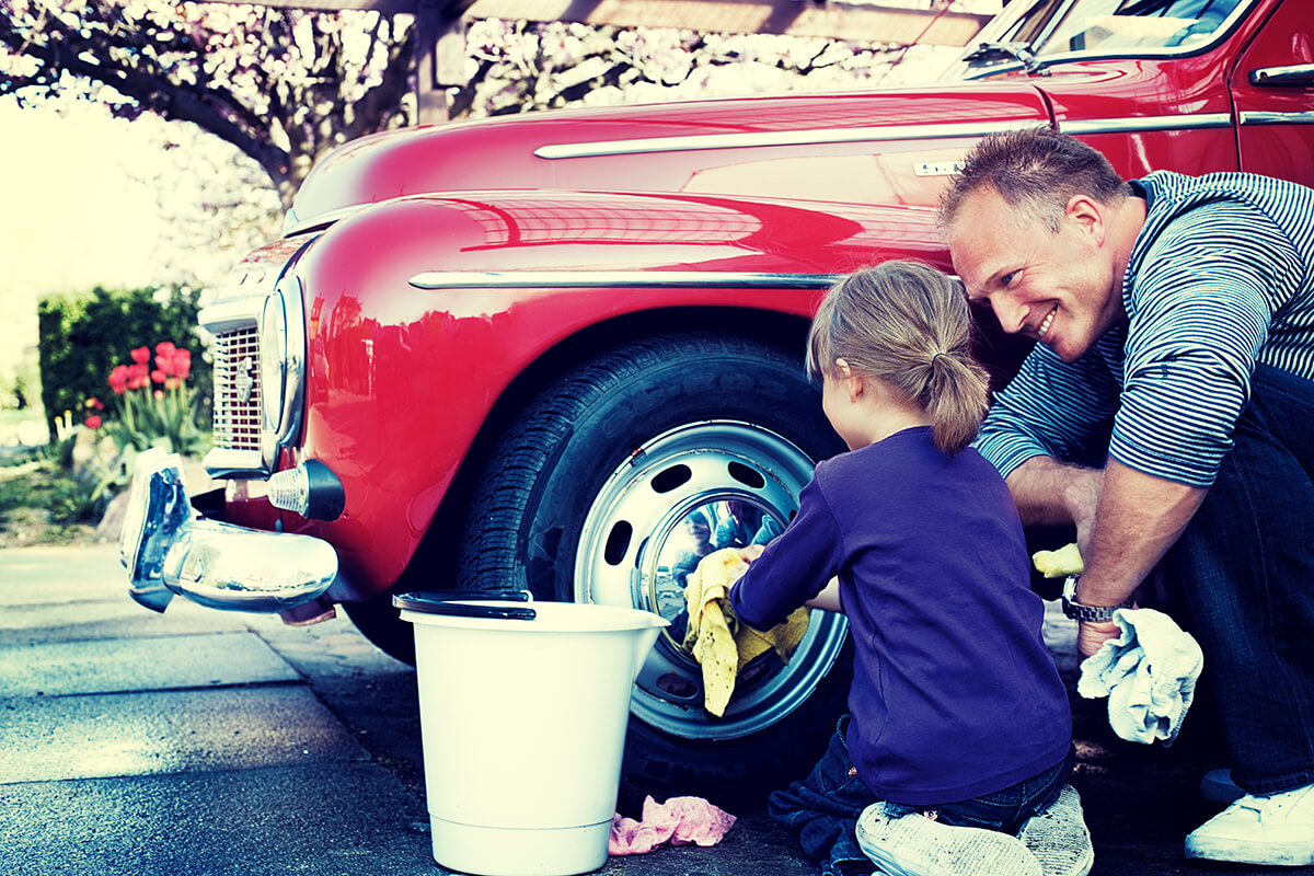Pappa och dotter tvättar bilen tillsammans