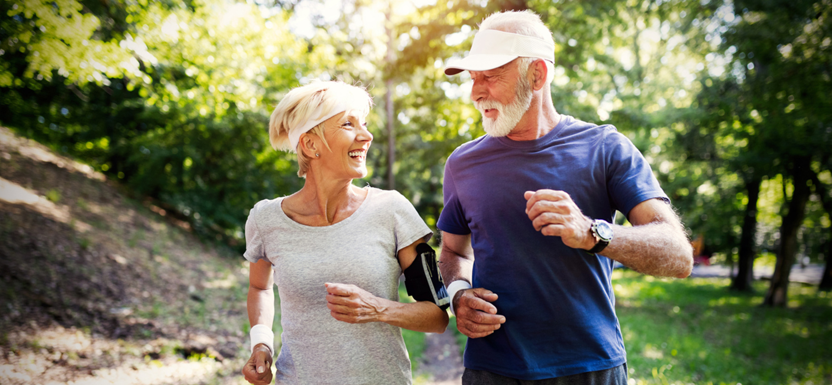 Ett par i pensionsålder är ute och springer i skogen