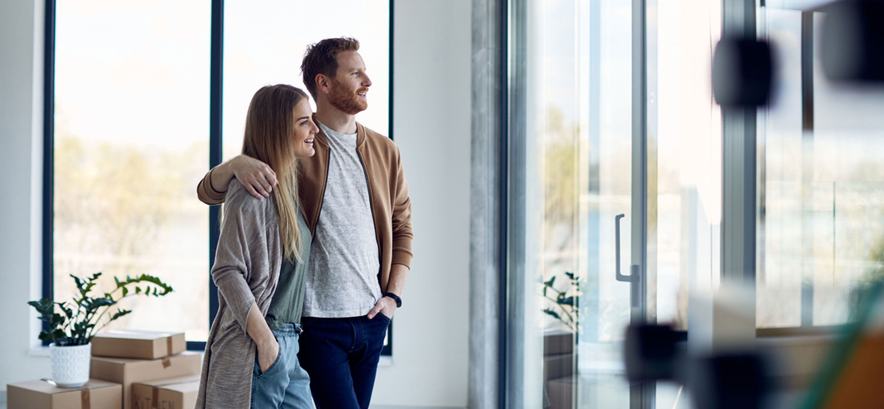 Ett par kollar ut genom fönstret på sin nya bostadsrätt