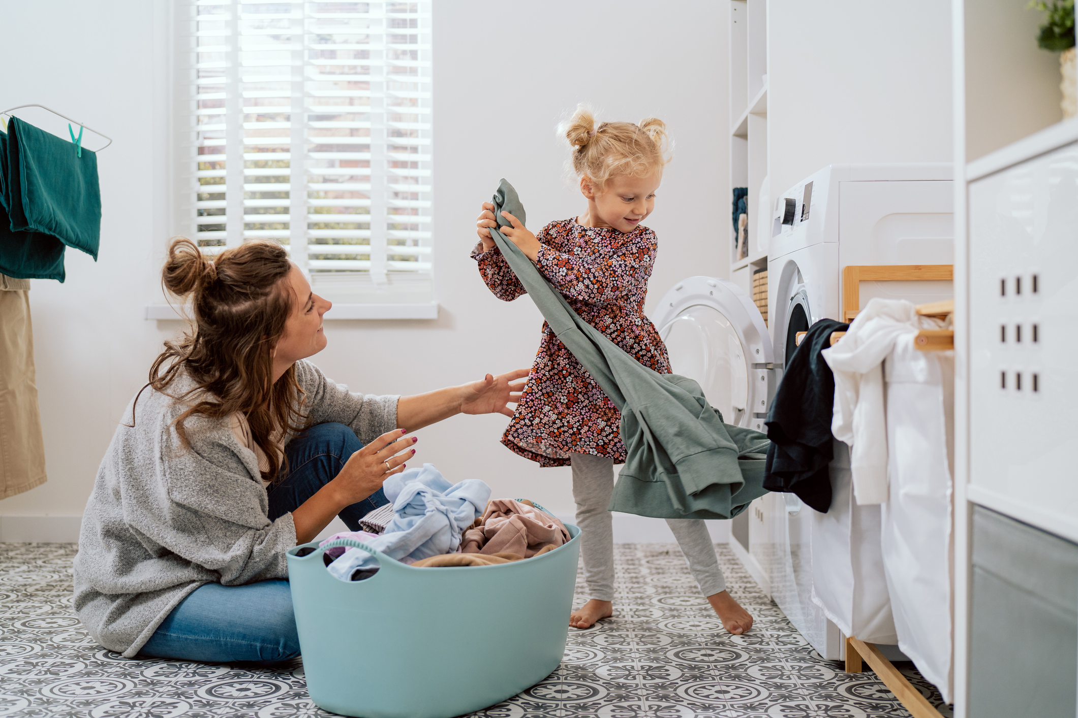 En mamma och dotter tömmer tvättmaskinen i badrummet