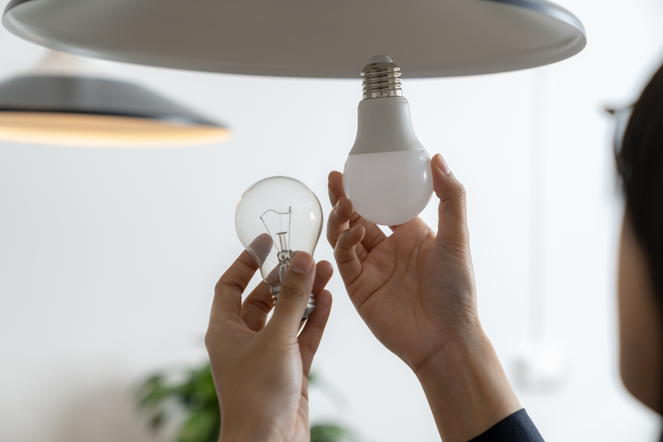 Någon byter en halogenlampa till LED-lampa