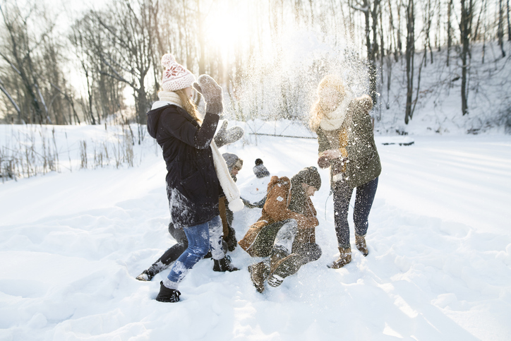 En familj bygger en snögubbe