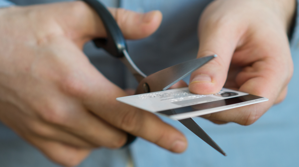 Person klipper ett kreditkort