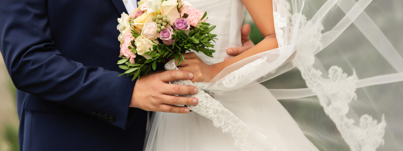 Brudpar som gifter sig och bruden håller i en blombukett