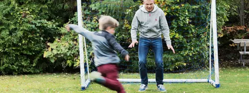 Pappa och son spelar fotboll