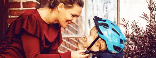 Mamma knäpper hjälm på sin son