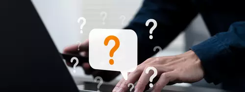 Person skriver på datorn och animerade frågetecken runtom