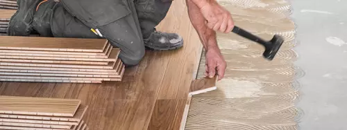 Man som lägger om golvet i sin bostad