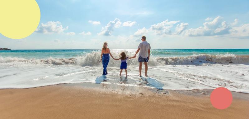 Familj vandrar på stranden