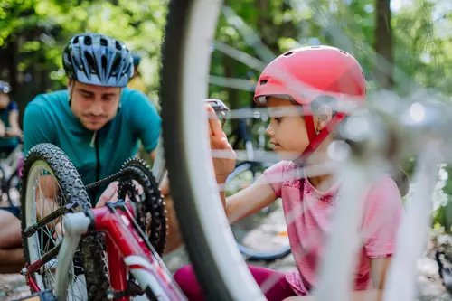 Pappa hjälper sin dotter med cykeln