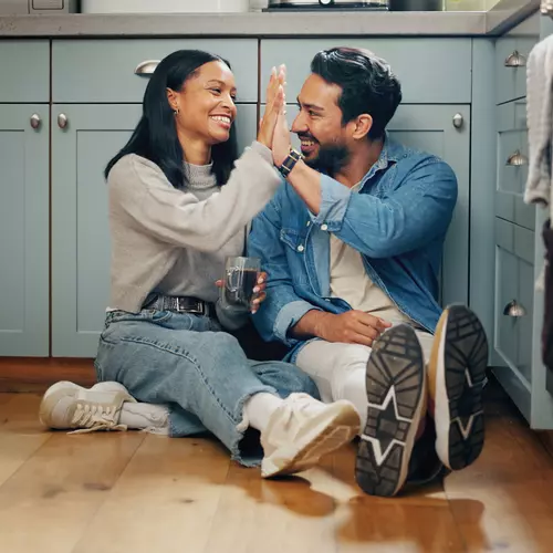 Ett par gör high five i ett nyrenoverat kök