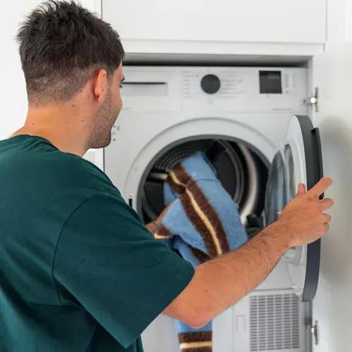En man står vid en tvättmaskin