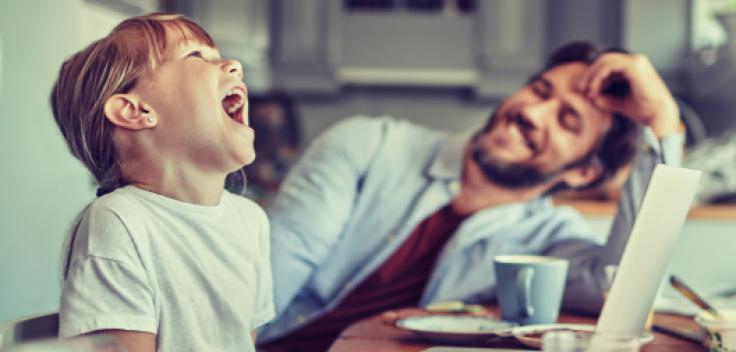 Dotter och far sitter vid köksbordet och äter frukost