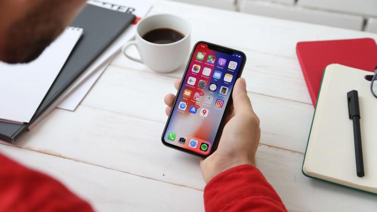 Kille kollar ekonomiappar på sin telefon