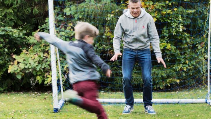 Pappa och son spelar fotboll