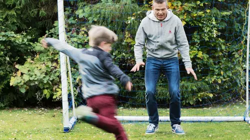 Pappa och son spelar fotboll