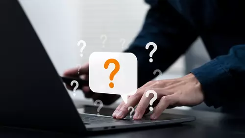 Person skriver på datorn och animerade frågetecken runtom