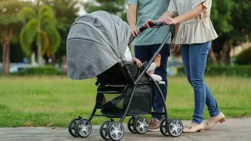 Par som är ute och går med sin barnvagn