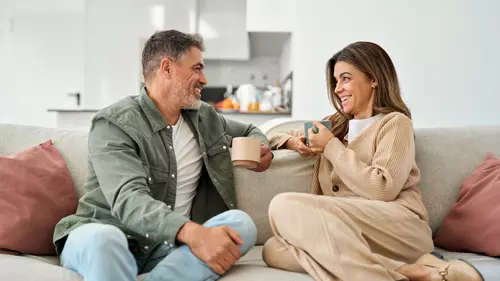 Par dricker kaffe i soffan och pratar ekonomi 