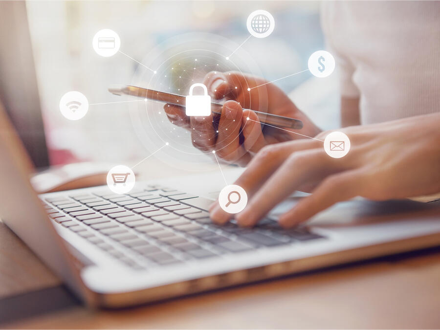 Person sitter vid mobilen och har olika verktyg runt sig som är viktigt att ha lösenord på