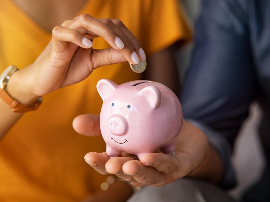 Par lägger ned pengar i en spargris